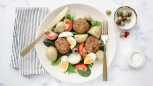 Juicy lamb rissoles with Nicoise salad, beans & egg recipe