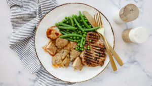 Smoky pork steaks with parmesan crusted potatoes, beans & peas recipe