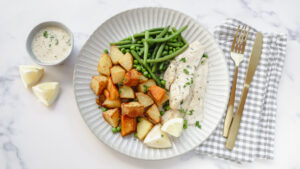 Fish with creamy parsley sauce, veggie roasties & greens recipe